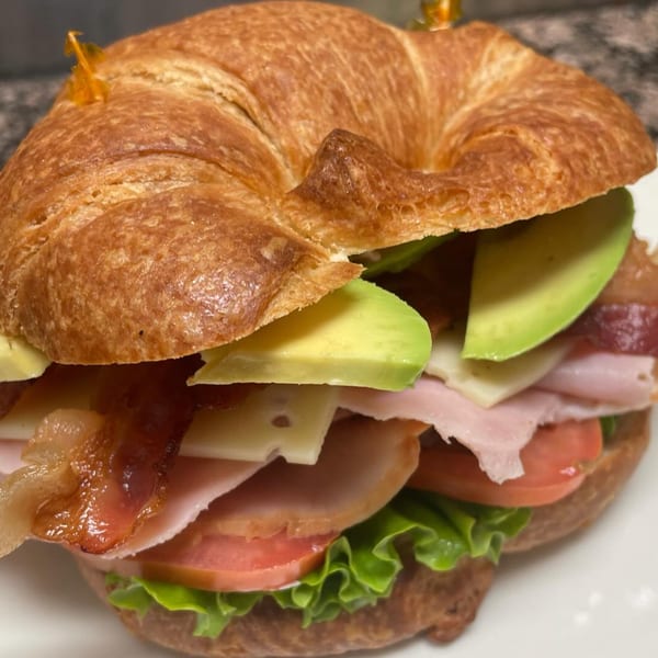 Croissant sandwich with bacon, avocado, ham, cheese, tomato, and lettuce from Courthouse Cafe.