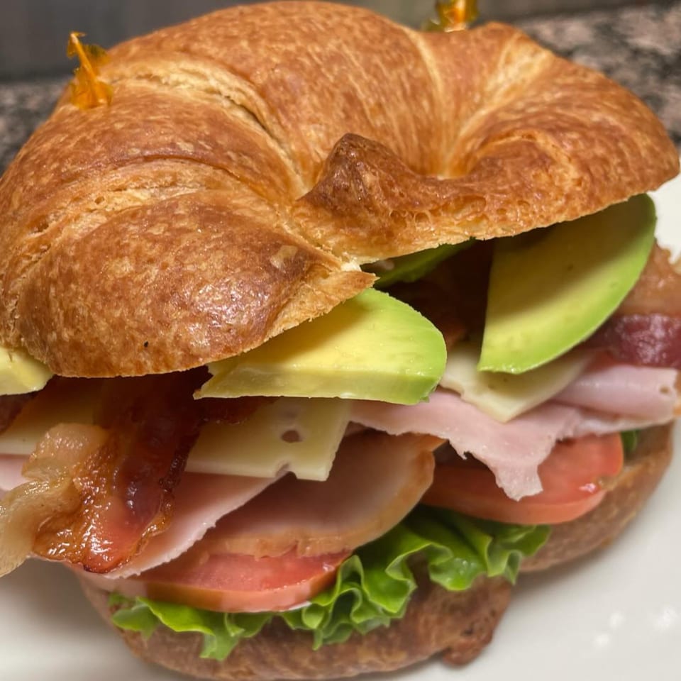 Croissant sandwich with bacon, avocado, ham, cheese, tomato, and lettuce from Courthouse Cafe.